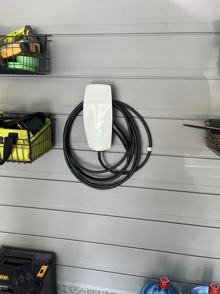 Tesla Wall Connector mounted on a garage storage wall
